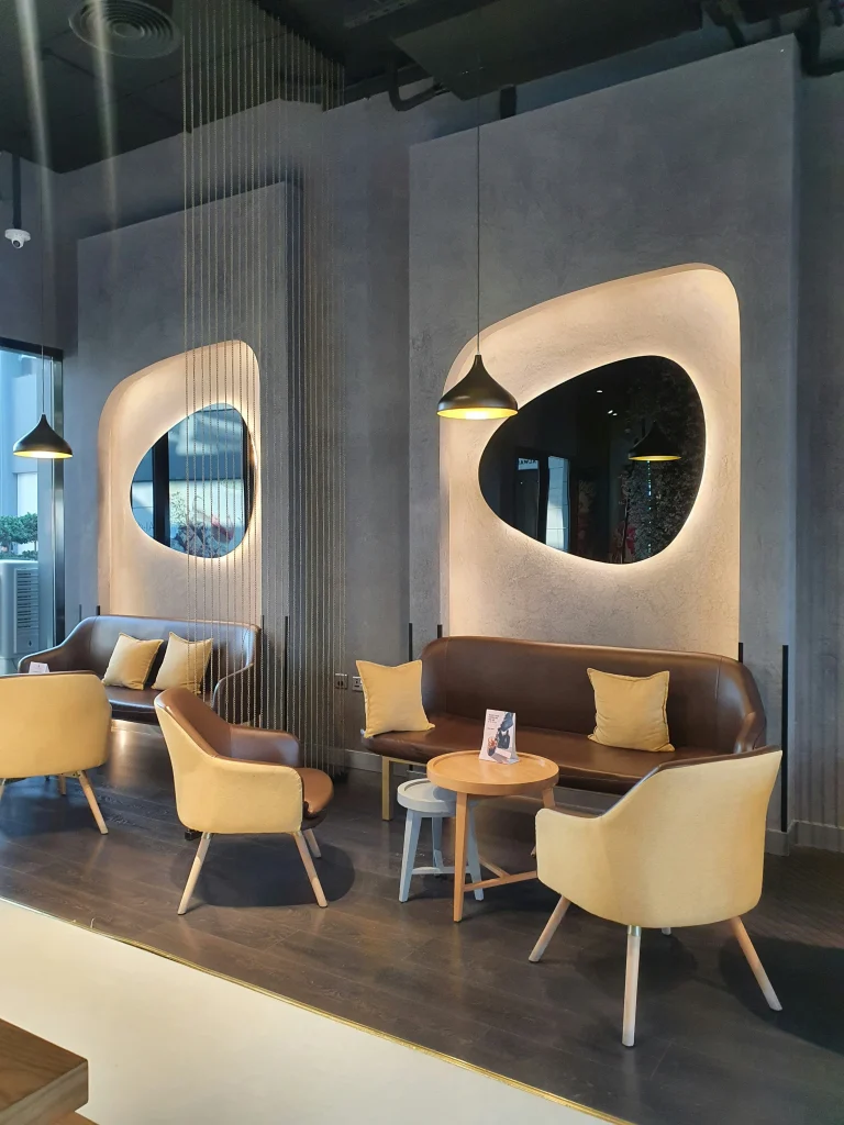 Intérieur moderne et cosy d’un café design à Bahreïn, idéal pour un moment de détente pendant un circuit.