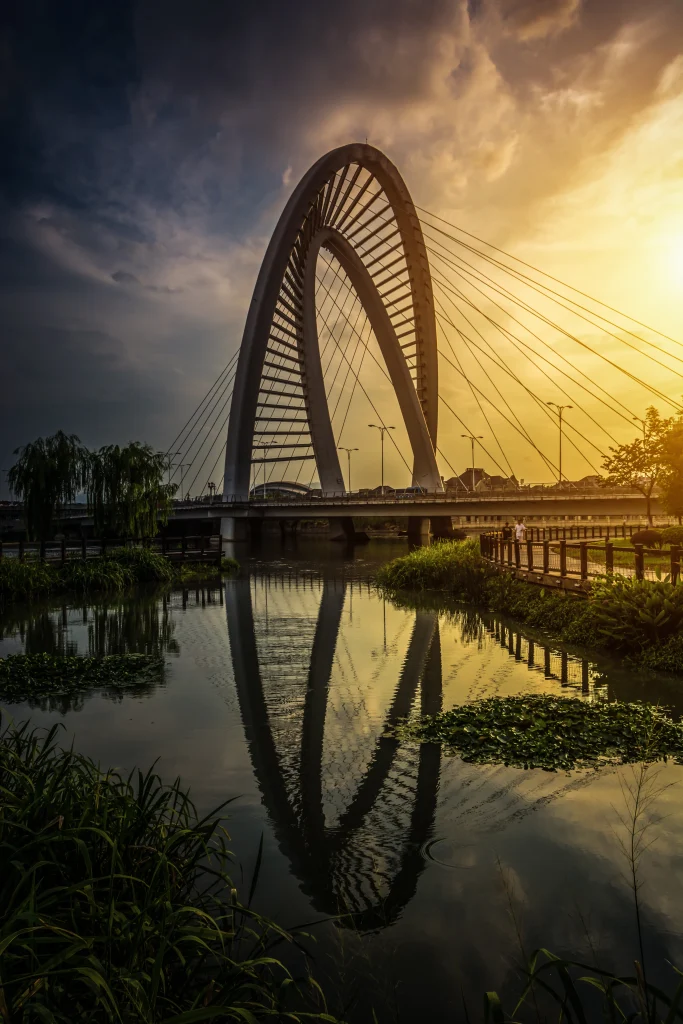Pont emblématique de Bahreïn au coucher du soleil – reflet sur l’eau, symbole de modernité et de sérénité.