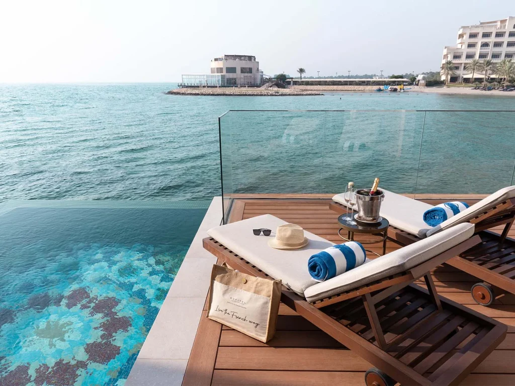 Terrasse privée d’un hôtel de luxe à Bahreïn avec vue sur la mer turquoise, idéale pour un séjour haut de gamme.